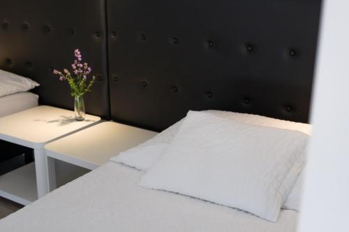 a bed with a vase of flowers on a table at Nefelejcs Vendégház in Gödöllő