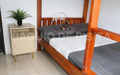 um quarto com 2 beliches e uma mesa de cabeceira em Baguio De Bisita em Baguio