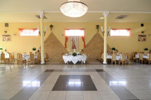 パビャニツェにあるHotel Pod Dębamiの宴会場(テーブル、椅子、シャンデリア付)
