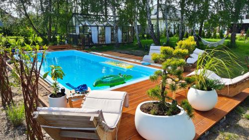 a swimming pool with potted plants on a wooden deck at Apartament Miętowe Marzenie in Chrzanów