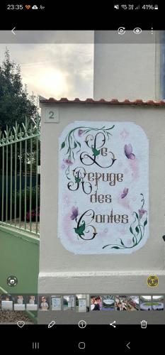un panneau sur le côté d'un bâtiment avec des fleurs sur celui-ci dans l'établissement Maison 15 minutes de Disney le refuge des contes, à Mareuil-lès-Meaux