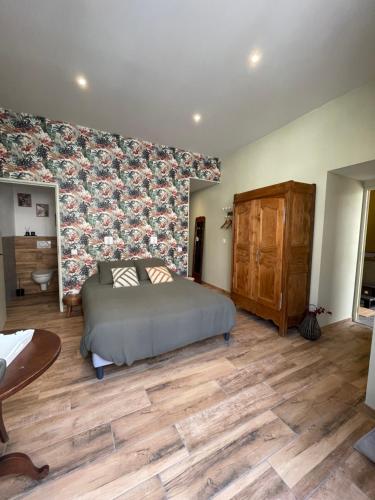 a bedroom with a bed and a floral wall at Maison Côté Halle La chambre de l'Artiste in Saint-Flour