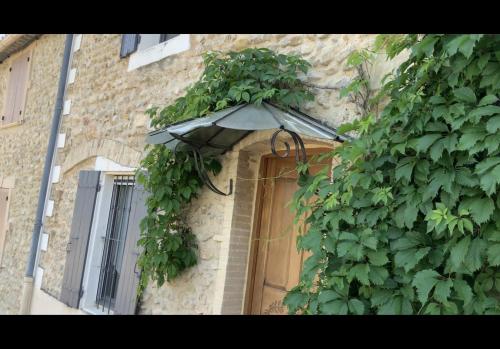 un bâtiment avec une plante sur son côté dans l'établissement Maison avec piscine en Drome provençale, à Saint-Maurice-sur-Eygues