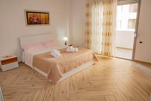ein Schlafzimmer mit einem Bett, auf dem zwei Handtücher liegen in der Unterkunft Seashell Apartment in Vlorë