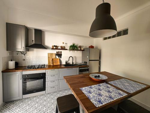a kitchen with a wooden table and a kitchen with a stove at Casa Velha de Vila Nova in Vila Nova de Milfontes
