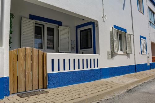 a blue and white house with a wooden fence at Casa Velha de Vila Nova in Vila Nova de Milfontes