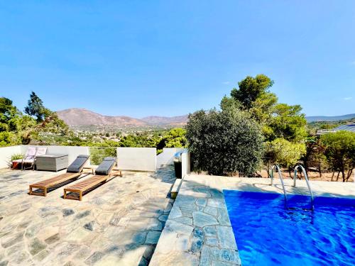 a swimming pool with two lounge chairs and a swimming pool at 2 bedroom self-contained apartment and swimming pool at Palm Tree Villa in Anavissos