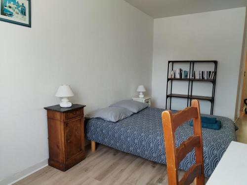 une chambre avec un lit et une table avec une chaise dans l'établissement superbe appartement centre ville saint grégoire, à Saint-Grégoire