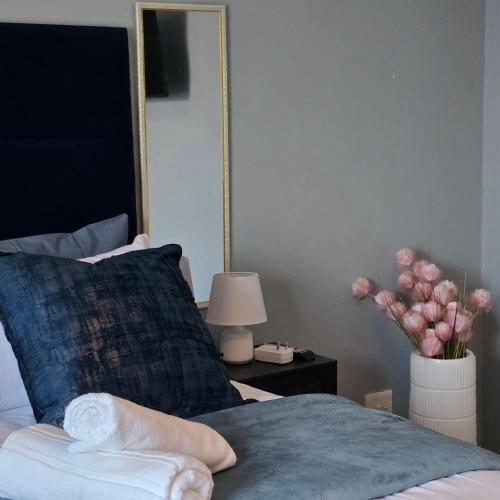 a bedroom with a bed with a mirror and a vase of flowers at Cosy Villa in Stegi