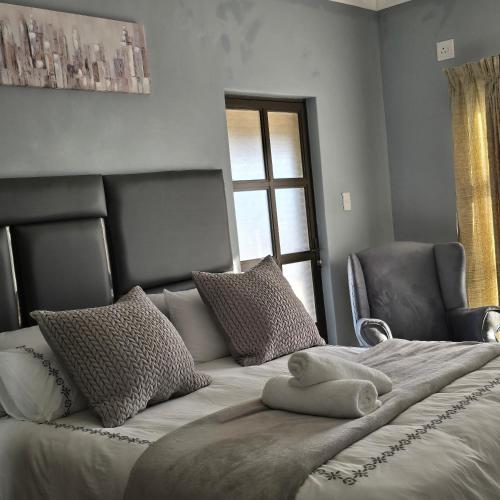 a bedroom with a large bed with two chairs and a window at Cosy Villa in Stegi