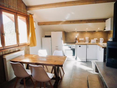 une cuisine avec une table en bois et des appareils électroménagers blancs dans l'établissement Ecogite Mercantour Ô Perché, à La Colmiane