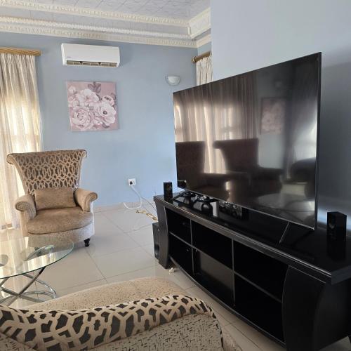 a living room with a large flat screen tv at Cosy Villa in Stegi