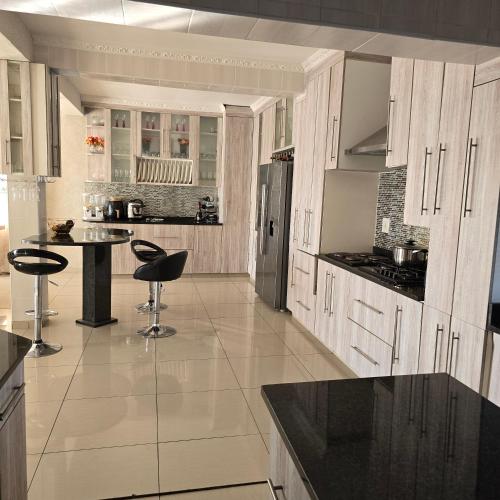a kitchen with white cabinets and a black counter top at Cosy Villa in Stegi