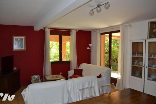 a living room with white furniture and red walls at La Roseraie gîte 3 épis avec piscine in Ruoms