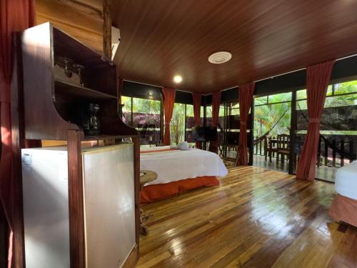a bedroom with a bed and a tv in a room at Hotel Heliconias Nature Inn & Hot Springs in Fortuna