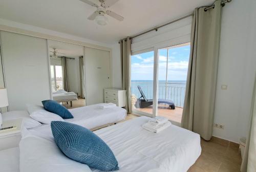 two beds in a room with a view of the ocean at Ref 200 in Las Lagunas Mijas