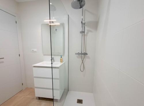 a white bathroom with a shower and a sink at Ref 200 in Las Lagunas Mijas