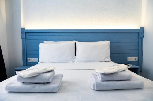 a blue bed with two towels on top of it at Mauna Hotel in Bozcaada