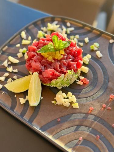 a plate with a red sauce and a lime on it at Central Gallery Rooms- Palazzo D'Ali' Staiti XIX in Trapani