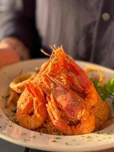 a plate of food with shrimp on a plate at Central Gallery Rooms- Palazzo D'Ali' Staiti XIX in Trapani