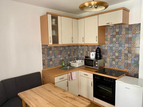 a small kitchen with a sink and a microwave at Petőfi24 Apartmanok in Siófok