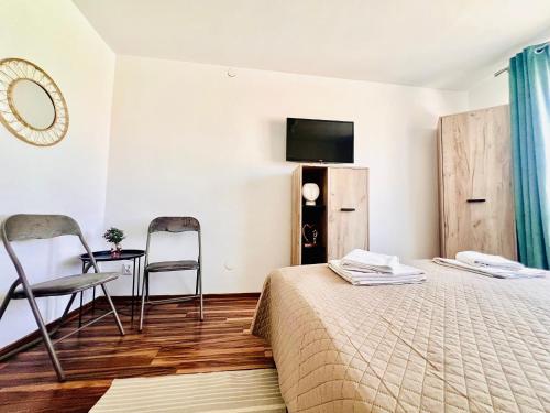 a hotel room with a bed and a table and chairs at S-HOUSE Avrig Apartament Spațios cu Terasă Privată lângă Sibiu in Avrig