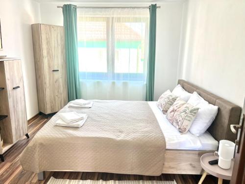 a bedroom with a large bed with a window at S-HOUSE Avrig Apartament Spațios cu Terasă Privată lângă Sibiu in Avrig