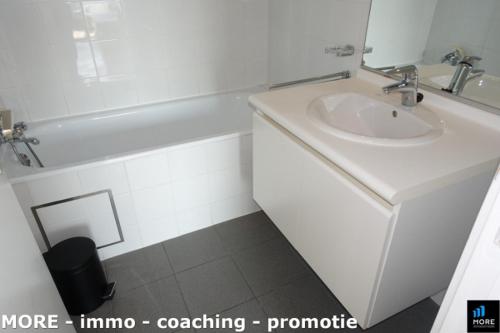 Un baño blanco con lavabo y bañera. en Studio in Laguna Beach, Knokke-Heist, en Knokke-Heist