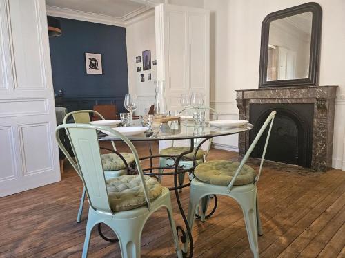 une salle à manger avec une table et des chaises et une cheminée dans l'établissement Le Galliéni Hyper Centre, au Havre