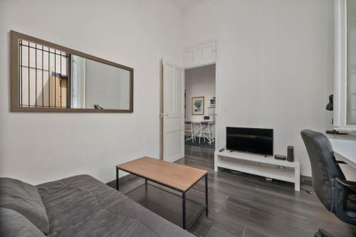 - un salon avec un lit, une table et une télévision dans l'établissement Nice et confortable 2 pièces cozy, à Nice