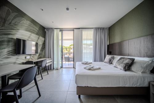 een hotelkamer met een bed, een tafel en stoelen bij Residence Diana in Bibione