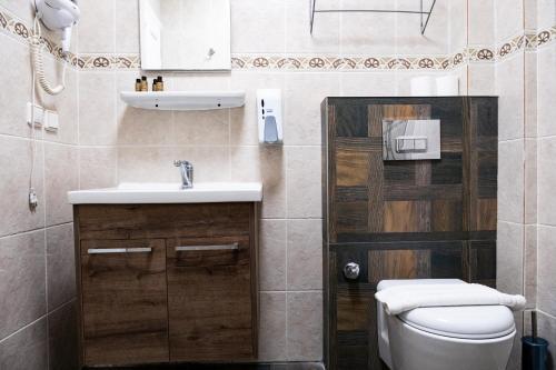 a bathroom with a sink and a toilet at Mauna Hotel in Bozcaada