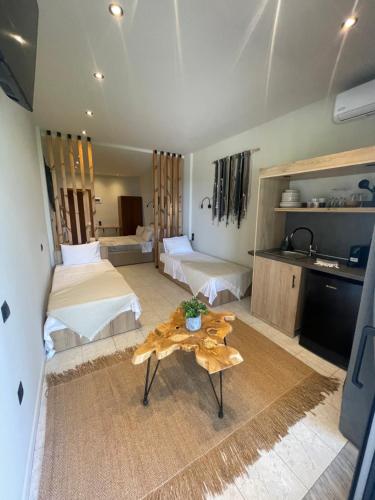 a bedroom with two beds and a table in a room at MOLA PAPAYA STUDIOS in Mola Kalyva