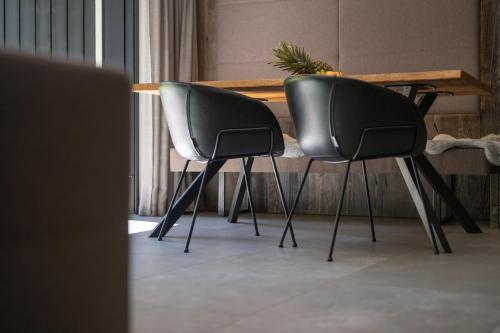 two black chairs sitting next to a table at Das luxuriöse alpine Apartment in der Residenz Silvretta - Inklusive Silvretta Card Premium in See