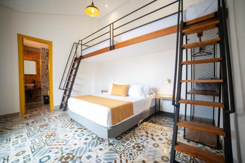 a bedroom with a bed and a spiral staircase at Casa Serafin Hotel in Salento