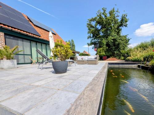 a patio with a koi pond and a house at Rêveries in Roeselare