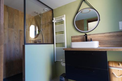 a bathroom with a sink and a mirror at Parenthèse Vexinoise 