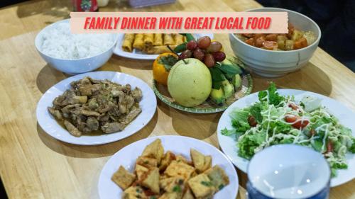 a wooden table with plates of food on it at Green Riverside Cosy Home in Bố Trạch
