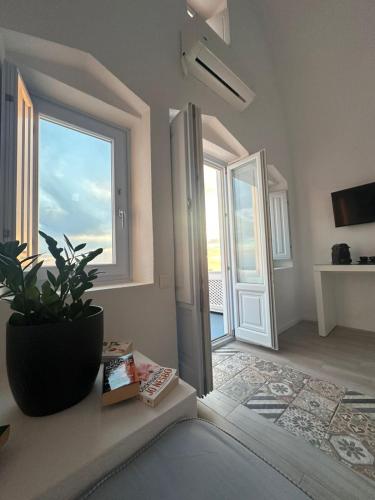 a room with a large window and a potted plant at Sunset Caldera Seaview Houses in Imerovigli