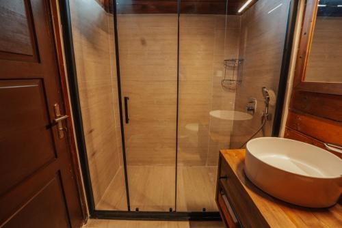 a bathroom with a sink and a glass shower at Sea Valley Lodge in Faralya