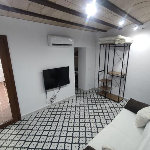 Una habitación con un televisor de pantalla plana en la pared. en Estudio en Blanes, en Blanes