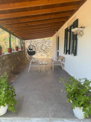 a patio with chairs and a wooden roof at Basil & Breeze in Lazaráta