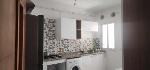 a kitchen with white cabinets and a sink and a window at S 3 a AFH Mrezga Hammamet in Hammamet Nord