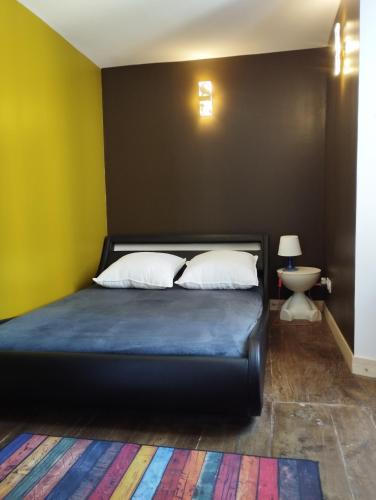 - une chambre avec un lit noir et 2 oreillers dans l'établissement Maison cévenole Alzon, à Alzon