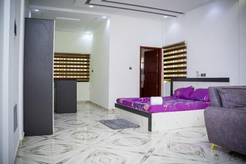a bedroom with a purple bed and a couch at Flowers House in Godomey