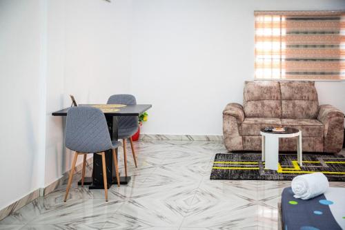 a living room with a table and chairs and a couch at Flowers House in Godomey