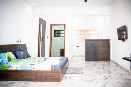 a bedroom with a bed and a tv in it at Flowers House in Godomey