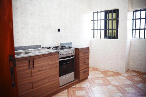 a kitchen with a stove and a sink at Flowers House in Godomey