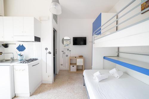 a white kitchen with a spiral staircase in a room at Vivilo Collection - Santa Laura Loft with Garden in Sperlonga