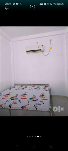 a bedroom with a bed with a floral sheet on it at Kashi Villa Fully AC Rooms in Varanasi